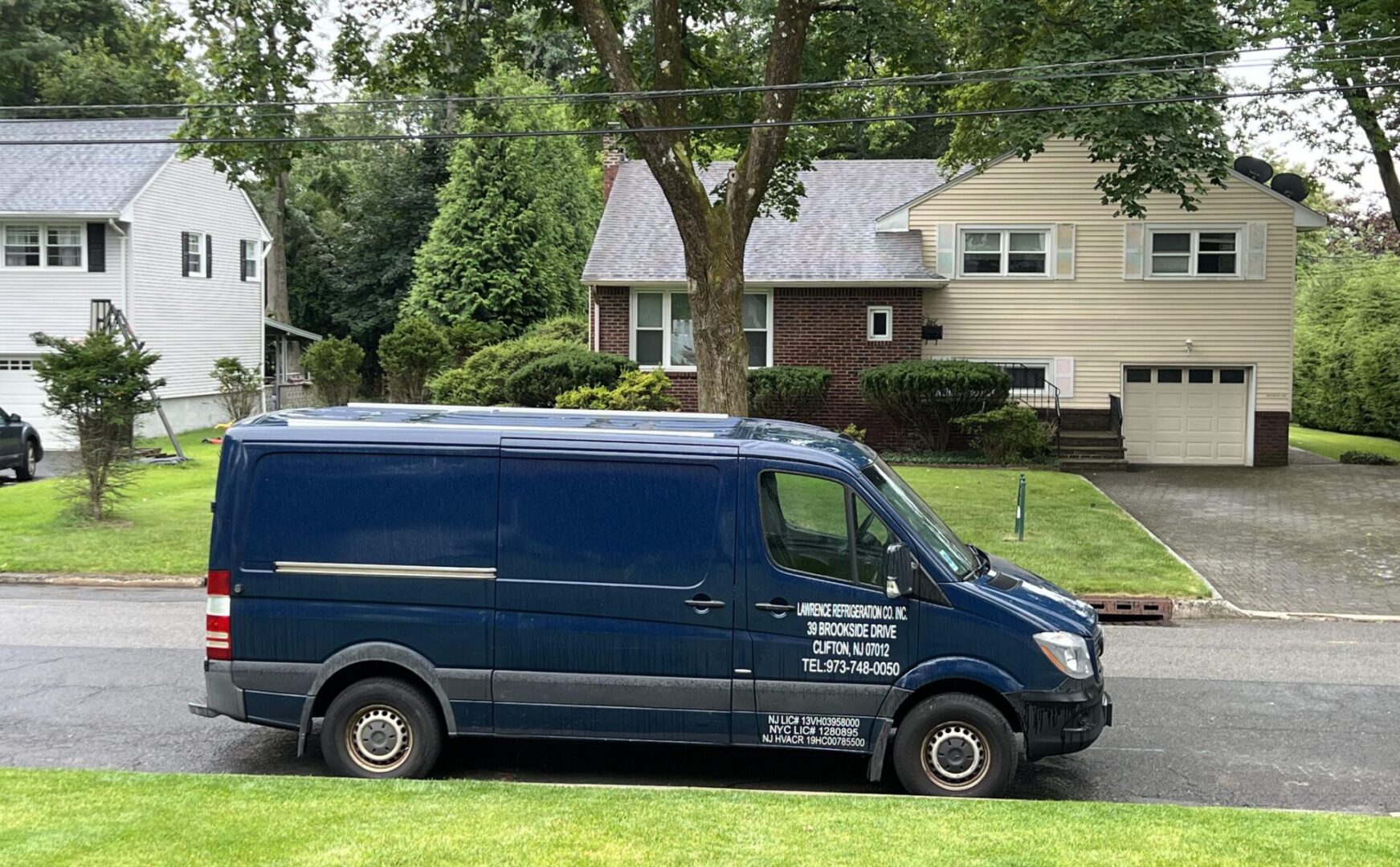 A van parked in front of a house on the street.